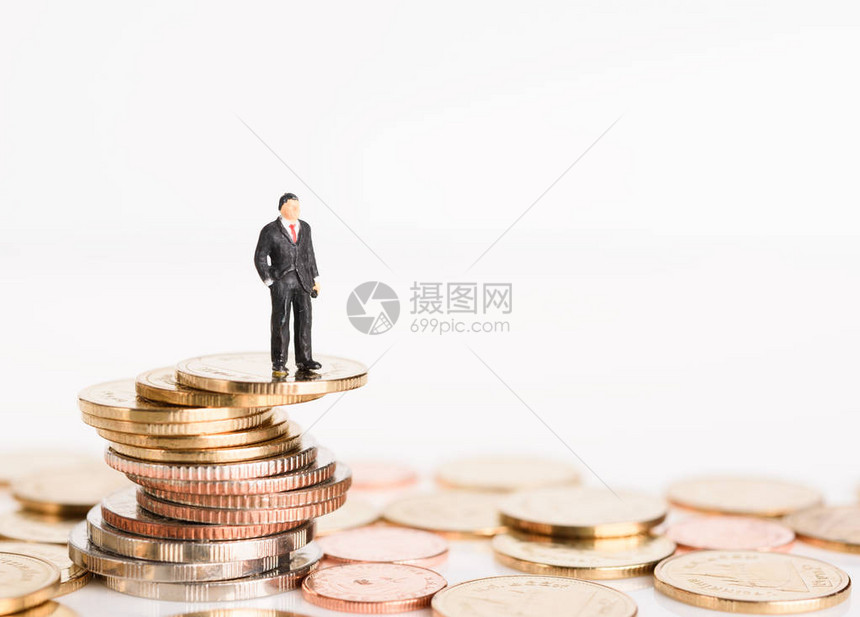 微型成功商人站在白色背景中孤立的金币之上图片