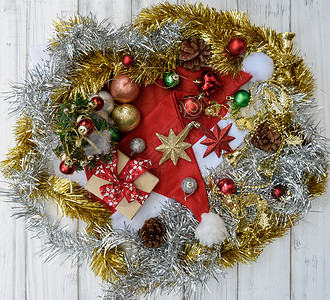 圣诞装饰品装饰着圣诞帽礼盒星白色木质背景上图片