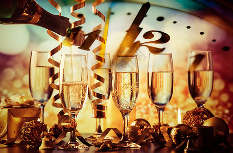 为新年晚会准备的节日灯下的香槟酒杯图片