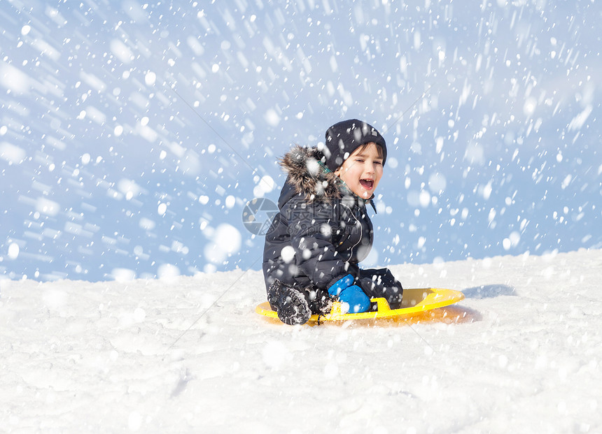 男孩在雪橇上滑雪冬图片