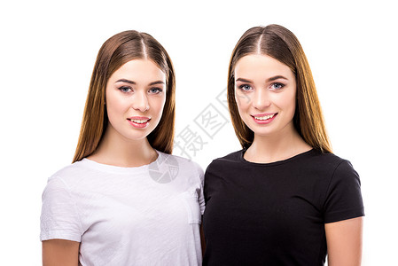 穿着黑白时尚服装的微笑双胞胎肖像图片