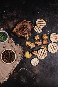 黑色混凝土表面美味烤牛排和茄子片的顶部视图图片