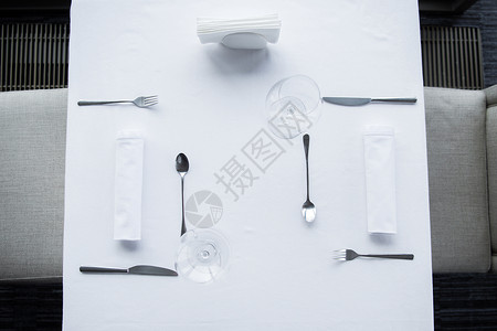 餐厅用白色桌布摆放的餐具和酒图片