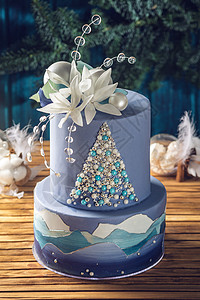 蓝色蛋糕和圣诞树和白花的画面绑在假日桌顶上喜悦甜点的图片