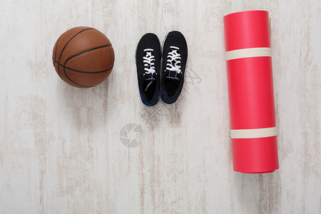 镶木地板顶视图上的运动器材篮球瑜伽垫和运动鞋积极的生活方式图片