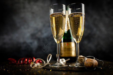 金色闪光深色背景中的两杯香槟酒杯图片