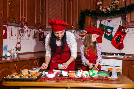圣诞晚会餐菜单甜点创意美味的巧克力薄荷纸杯蛋糕配咖啡奶酪油和糖洒妈和女儿一起背景图片