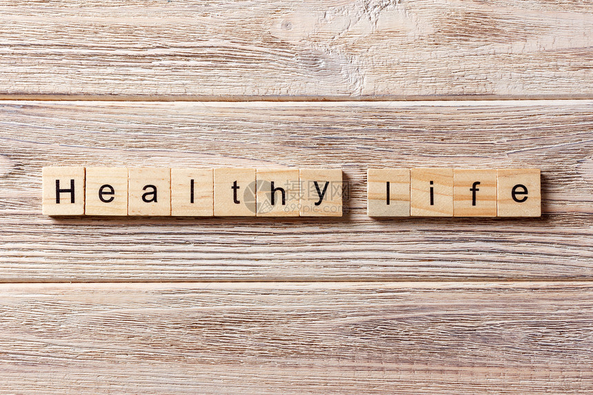 在木块上写着健康生命的字句健康的人生文字放在图片
