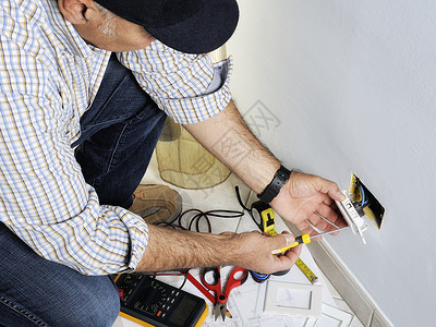 电工在住宅电气系统的开关和插座上工作图片