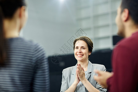 快乐的中年女商人双手合十听同图片