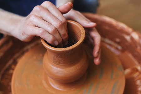 用陶轮制作陶罐的手工艺人图片
