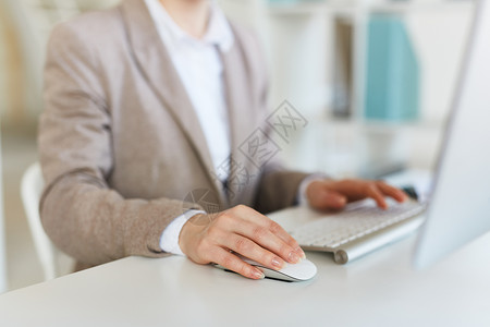 在电脑工作期间用手抓老鼠的女商图片