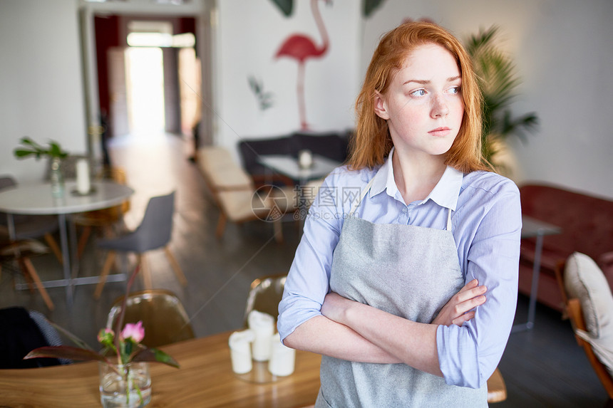 身穿严重制服的女服务员在胸前交叉手臂图片