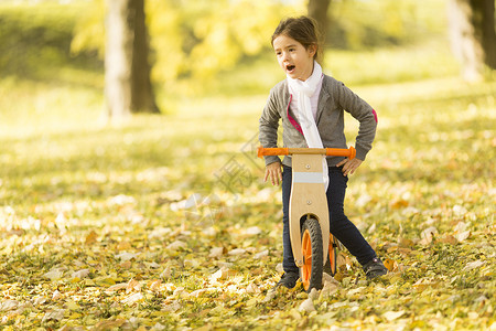 在秋天公园看小女孩骑图片