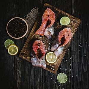 生木桌上鲜红鱼和香料及柑橘水图片