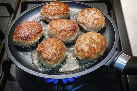 锅里放着火炉的油炸烤肉饼图片