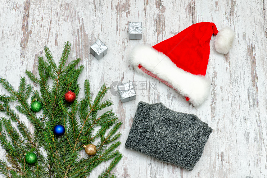 圣诞老人帽子装饰着花枝和灰色的毛衣图片