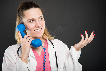女医生在蓝色电话接收器上讲话图片