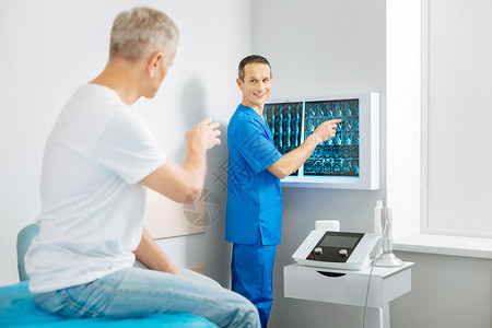 诊断说明快乐的好医生站在X射线图像附近图片