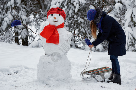 穿着编织帽子雕塑的女孩给雪图片