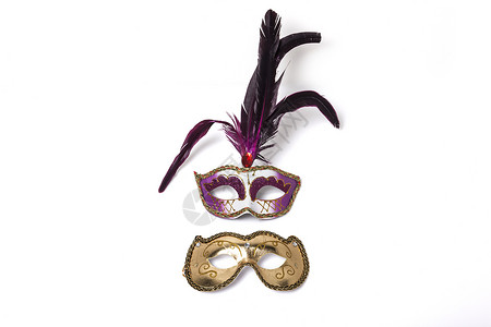 用羽毛和光亮的金面罩遮住白色背景的紫图片