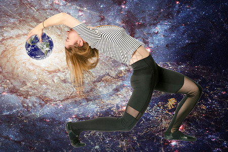 年轻的运动瘦处女座生肖女孩与银河背景上的行星地球向后弯曲图片