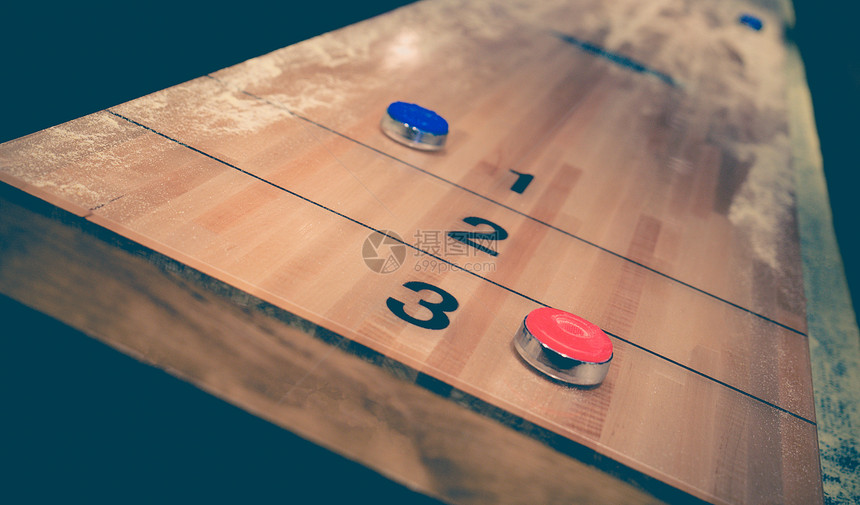 老式洗牌棋盘游戏与木制洗牌桌上的红色和蓝色圆盘具有选择焦点的图片