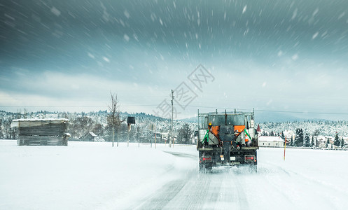 冬季服务卡车或灰熊在公路表面撒盐图片