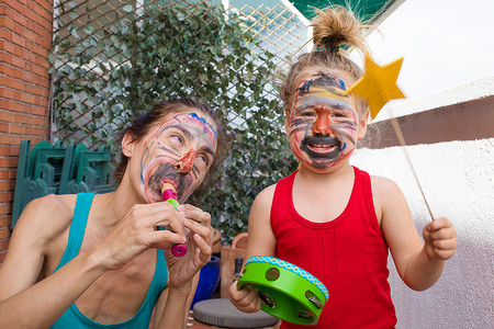 女人和三岁的孩子画着脸背景图片