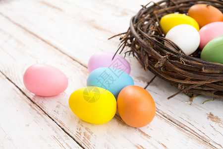 五颜六色的复活节彩蛋在仿古木板背景上的巢穴中春季假期复古柔和的色图片