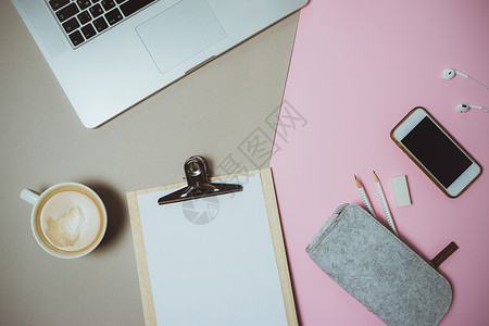 粉色和灰色桌子上有笔记本电脑咖啡和文具的创意图片