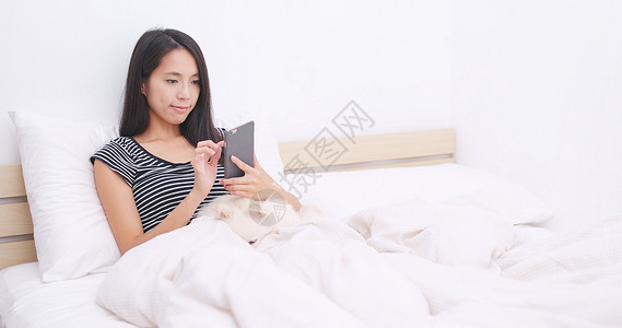 在家床上使用手机的妇女在家图片