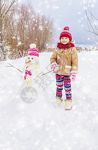 冬天的孩子在雪中做雪人图片