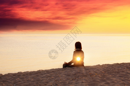 年轻女子在沙滩上做瑜伽内光概念精神背景背景图片