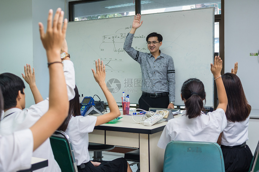 亚洲老师在科学实验室课堂上讲授白板上的物理公式图片