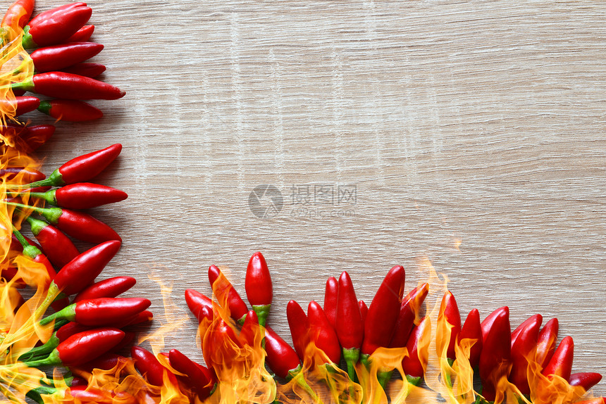 木板上有火焰的红辣椒图片