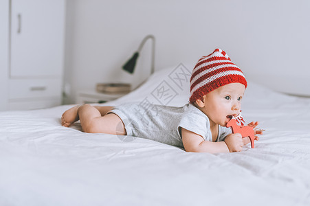 戴着红白条纹帽子的婴儿在床图片