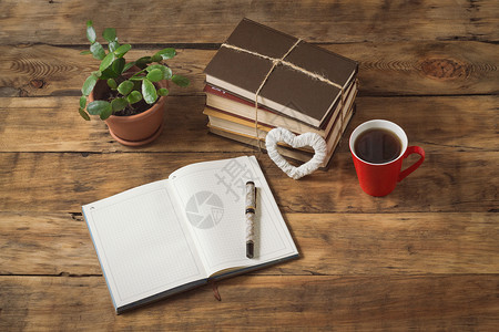 日记心脏花朵书卷红杯加咖啡或茶木制桌上的笔照片图片