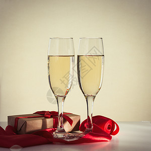 包装好的礼物两杯香槟和一条红丝带图片
