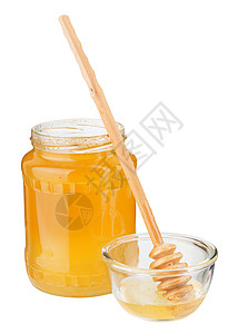 甜的新鲜蜂蜜在罐子和木制花瓶中图片
