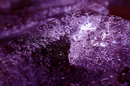 一块冰在紫外线的水中有结冰的气泡图片