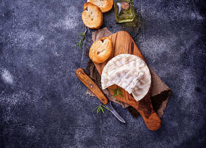 卡门培尔奶酪配迷迭香在木板上顶视图图片