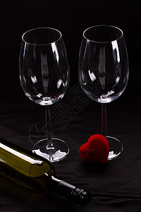 两个酒杯瓶子和礼品盒两个空酒杯和黑色背景上的小心形天鹅绒礼盒情人图片