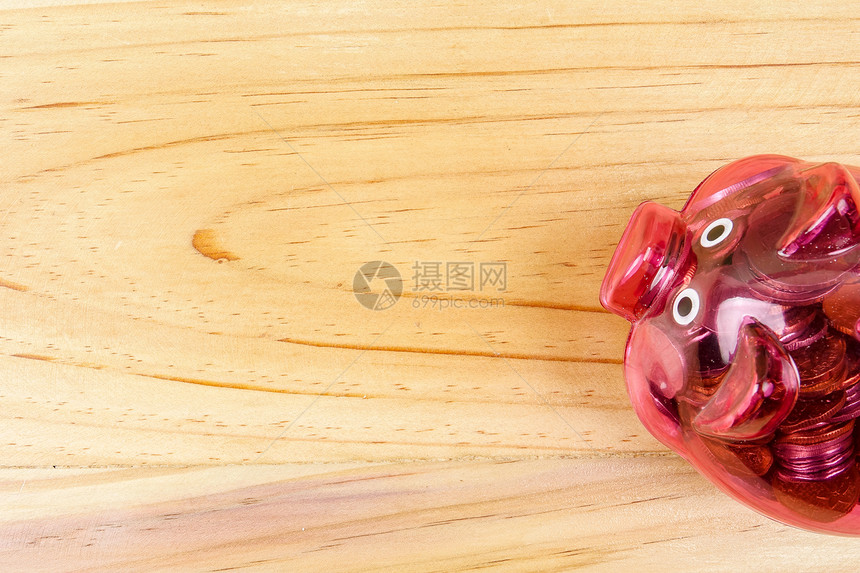 红猪银行和一罐硬币放在木制桌上储图片