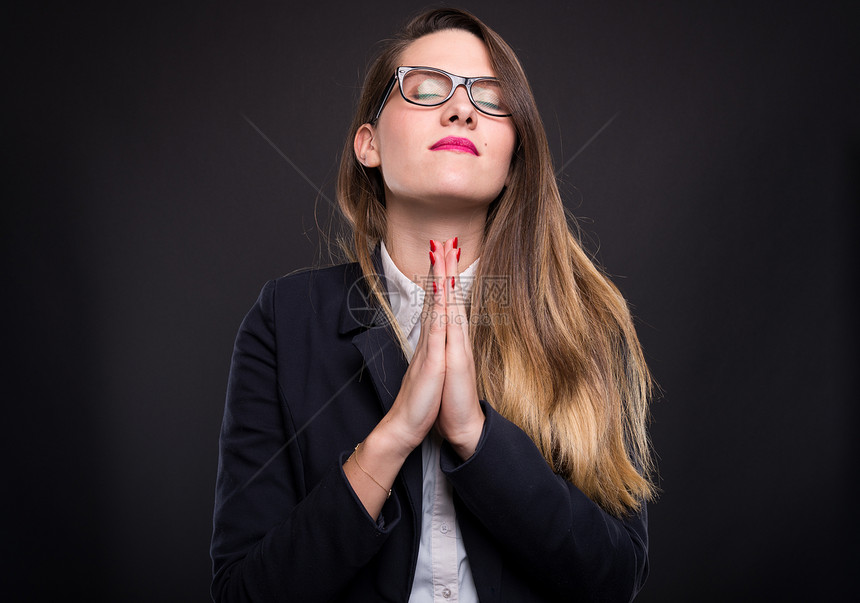 年轻女子双手合十祈祷图片