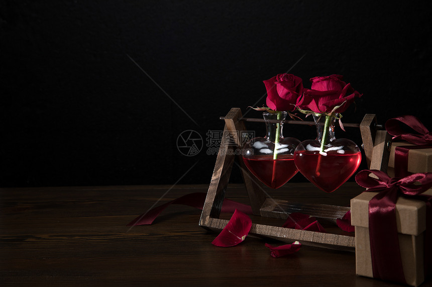 两朵红玫瑰在心脏形状的花瓶木图片