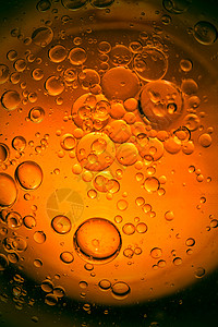 黄色和橙色的泡沫以及水中的油滴橄榄油厨图片