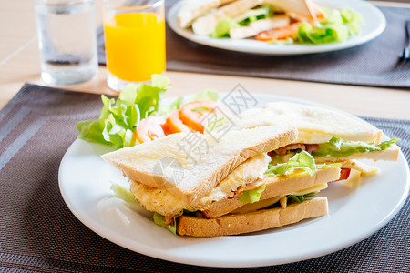 早餐时带白盘蔬菜的俱乐部面包和三明图片