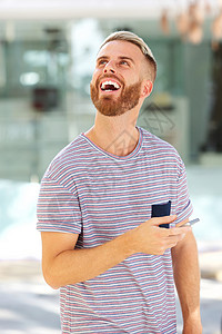 年轻人用手机笑的肖像图片