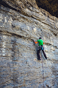 一个人克服了艰难的攀爬路线在岩石上攀岩图片